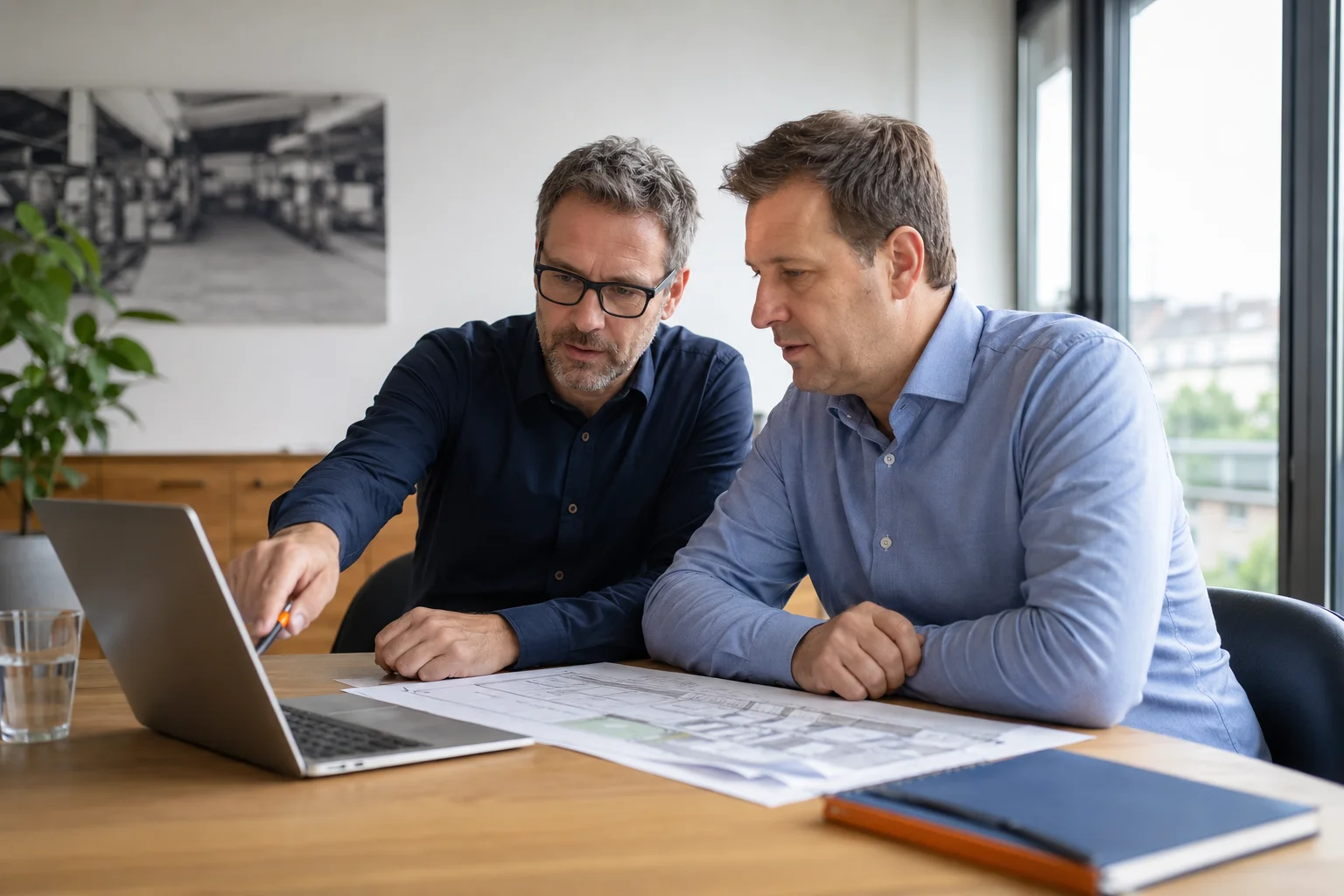 Berater und Kunde stimmen sich gemeinsam an einem Laptop ab